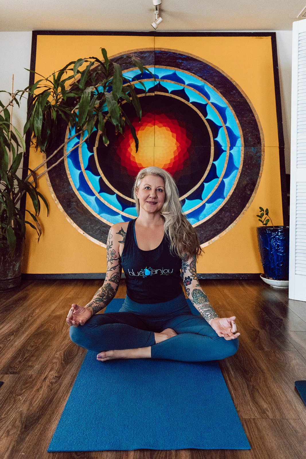 Teacher seated in meditation in front of the mandala painting