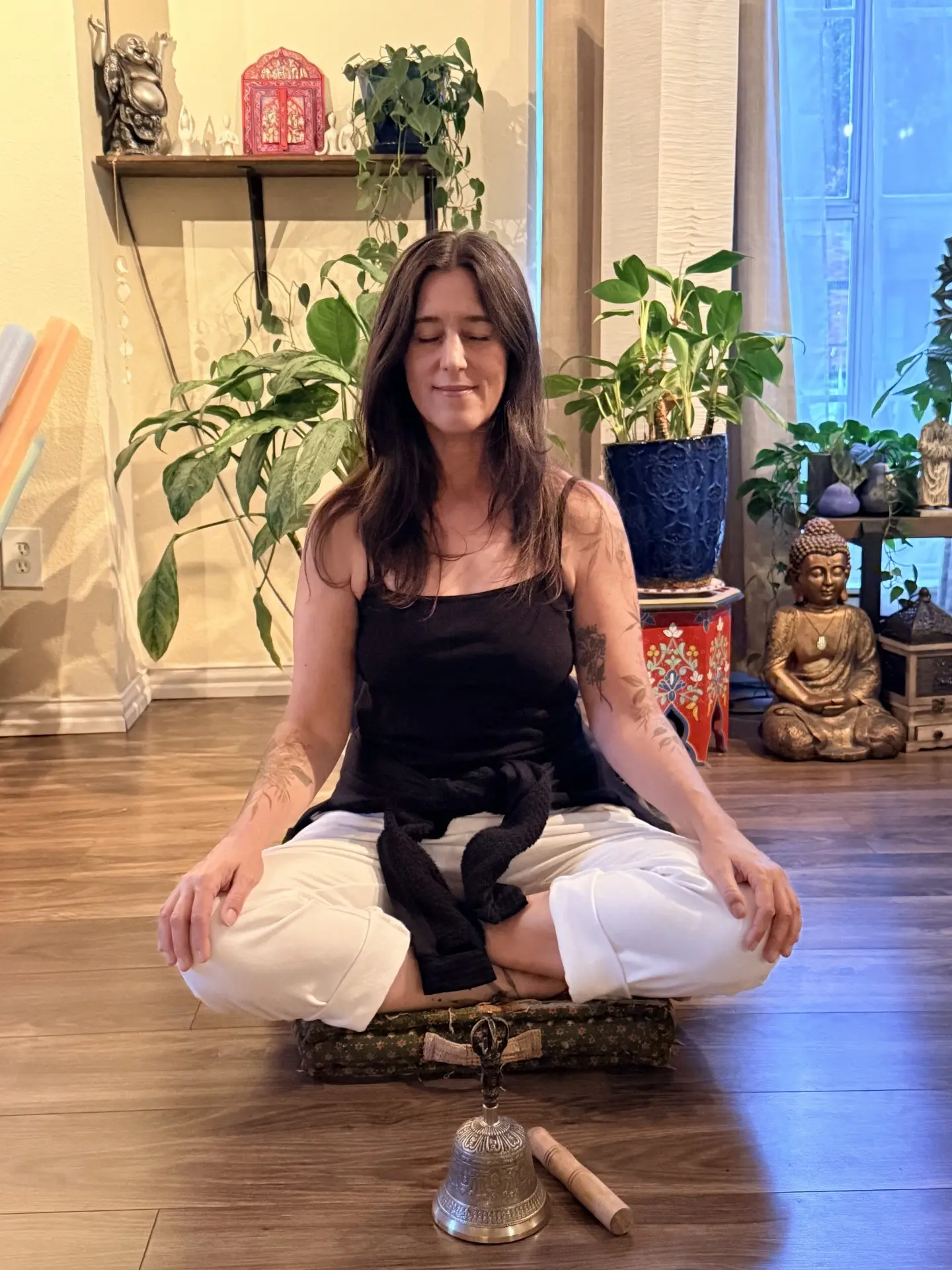 Teacher seated in meditation with a singing bell at Blue Anjou