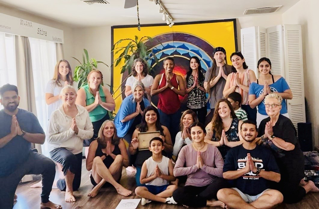 Blue Anjou yoga community gathered in namaste after class