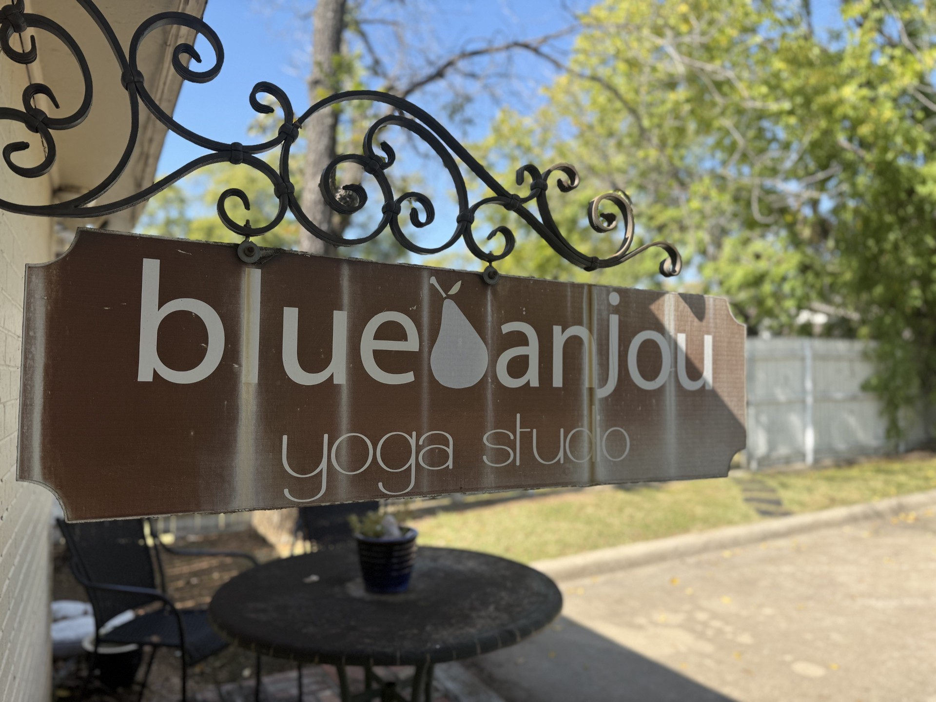 Blue Anjou Yoga Studio hanging sign outside the studio